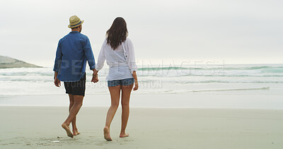 Buy stock photo Beach, couple and walking on sand or holding hands on honeymoon, holiday or bonding outdoor. Woman, man and relationship by sea for memory, romantic date and back with love and sunset stroll by space