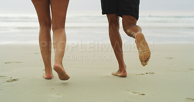 Buy stock photo People, feet and walking on beach sand for holiday, weekend or vacation together in nature. Closeup, legs and barefoot with water, ocean coast or sea waves for fun day, playful or outdoor bonding