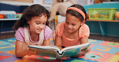 Buy stock photo Girls, reading book and friends on ground, school and relax with education, break and bonding together. Learning, storytelling and children in classroom, literacy knowledge and happiness with kids