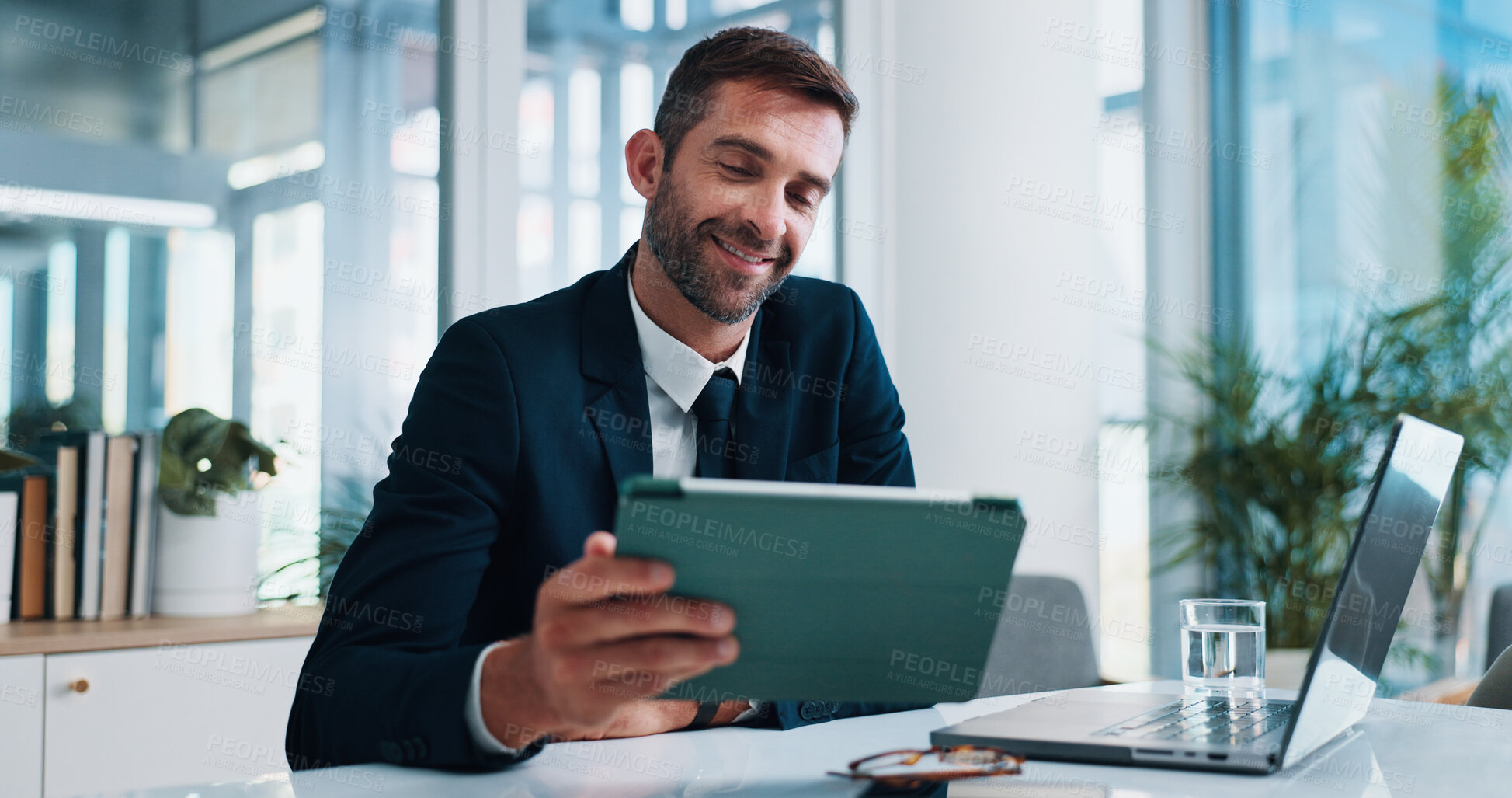 Buy stock photo Man, tablet and happy with laptop in office with stats, review and research with fintech application. Person, financial advisor or broker on touchscreen with investment, audit and revenue at agency