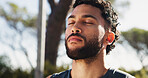 Calm man, breathing and fitness with mindfulness in nature for zen, workout or exercise at outdoor park. Face, male person or eyes closed with peace or spiritual technique for health, rest or break