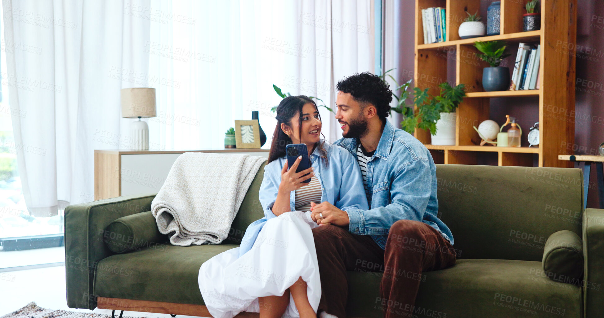 Buy stock photo Couple, phone and gossip on sofa with hug, social media and funny story in home. Woman, man and smartphone in living room for storytelling, comedy and celebrity news on timeline with internet bonding