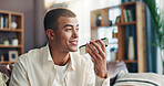 Speaker, voice note and happy man with phone in home for communication, talking and chat on call. Online, mobile app and person on smartphone for connection, communication and contact in living room