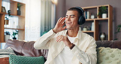 Buy stock photo Happy man, relax and listening with headphones on sofa for music, podcast or radio sound at home. Male person, listener or smile with tune for audio vibe, song playlist or rhythm on couch at house