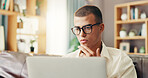 Glasses, student and man on sofa with laptop for online research, studying and elearning for college. Remote work, home and person on computer for project, assignment and education for university