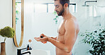Man, lotion and skincare with dispenser in bathroom for hygiene, anti aging or grooming at home. Male person, product or face cream with SPF or mirror for facial treatment or dermatology at house