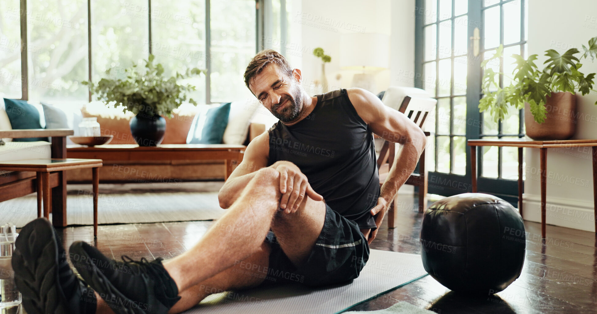 Buy stock photo Fitness, home and man with back ache, injury or accident for intense workout with mistake. Sports, exercise ball and person with muscle sprain, discomfort or spine pain for training error in house.