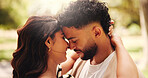 Forehead touch, hug and couple on date, outdoor and romance for people in nature, love and anniversary. Park, woman and affection for man, happy and together for valentines day, care or commitment