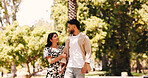 Walking, holding hands and couple with smile, park and romance for people in nature, love and anniversary. Outdoor, woman and affection for man, happy and together for valentines day or commitment