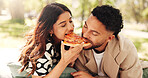 Couple, lunch and eating pizza outdoor at picnic together for romantic date or bonding for relationship. Man, woman or share fast food at park, hungry or enjoy takeaway to relax with partner for love