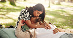 Bonding, kiss and couple on date, picnic and affection for man in nature, embrace or relationship. Relax, park and romance with woman on anniversary, people and together for break, weekend or outdoor