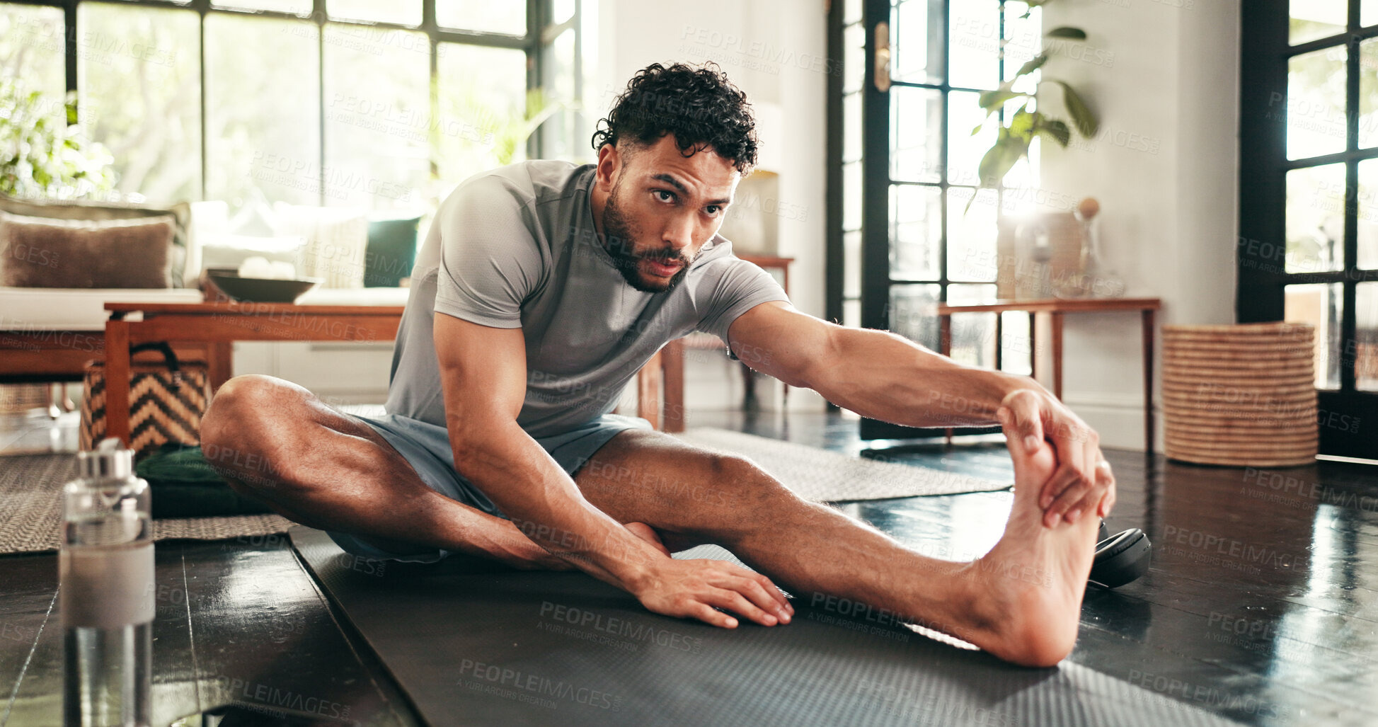 Buy stock photo Man, exercise and leg stretching in home for warm up, workout or fitness for training or muscle. Endurance, goal and athlete person for cardio, wellness and balance on floor with mat for challenge