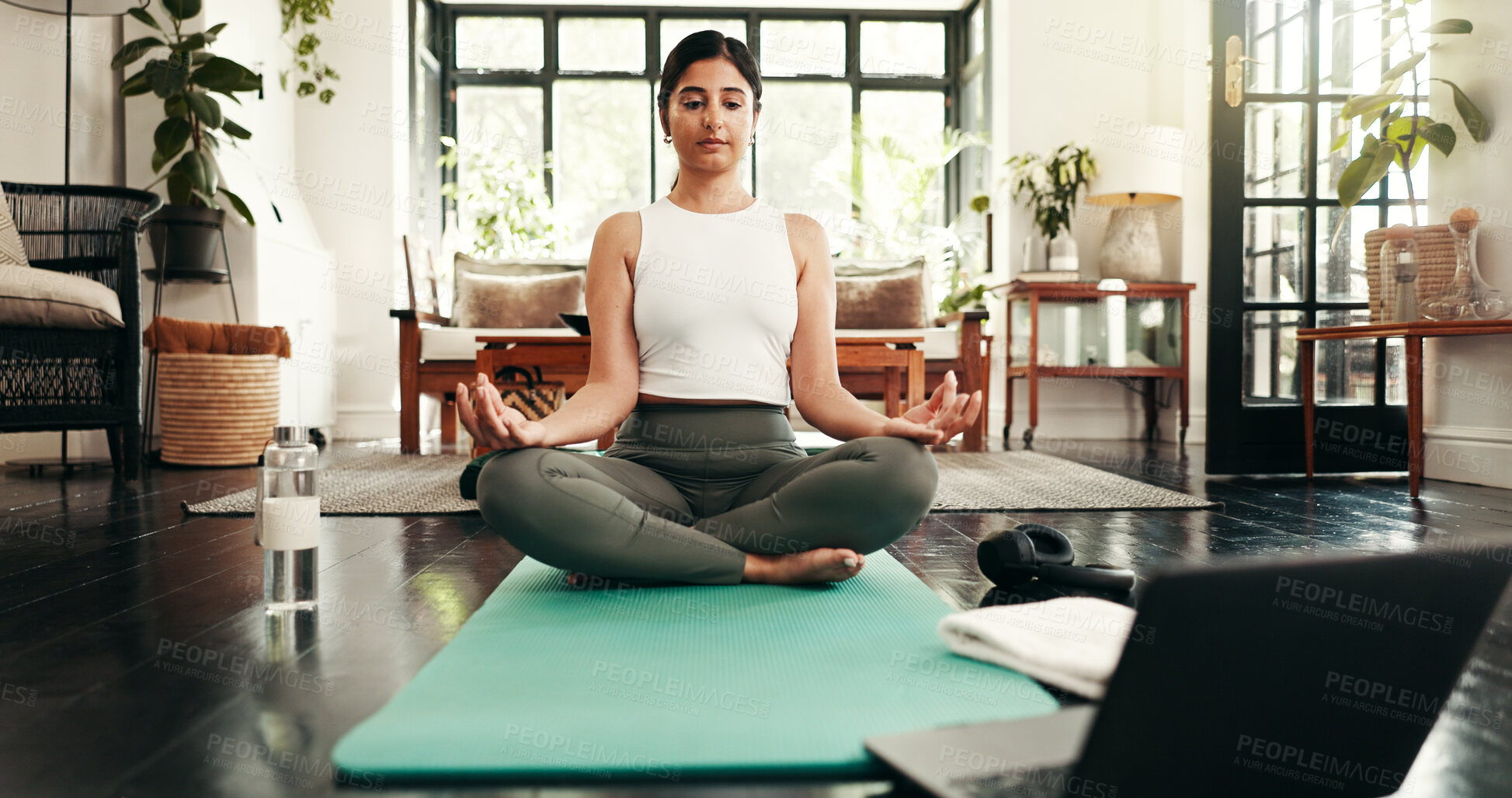 Buy stock photo Exercise, laptop and meditation with woman in living room of home for balance, health or wellness routine. Computer, inner peace and yoga with Indian person on floor of apartment for online course