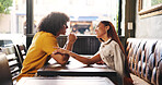 Date, flirting and talking with couple in coffee shop together for bonding, love or romance. Conversation, smile or touching with man and woman in booth of cafe for hospitality, relax or service