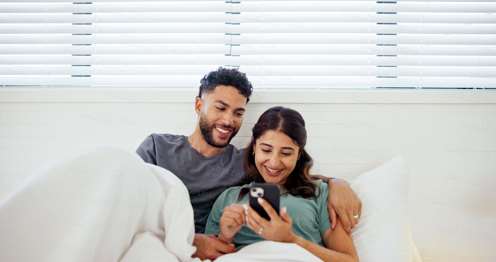 Buy stock photo Relax, phone and couple in bed at home for social media, online website and internet in morning. Happy, wake up and man and woman on smartphone for reading chat, bonding and relationship on weekend