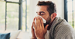 Sick, man and sneezing with blanket in home for flu symptoms, fever and respiratory disease on sofa. Illness, person and virus infection in living room with bacteria, blowing nose and sinus allergy