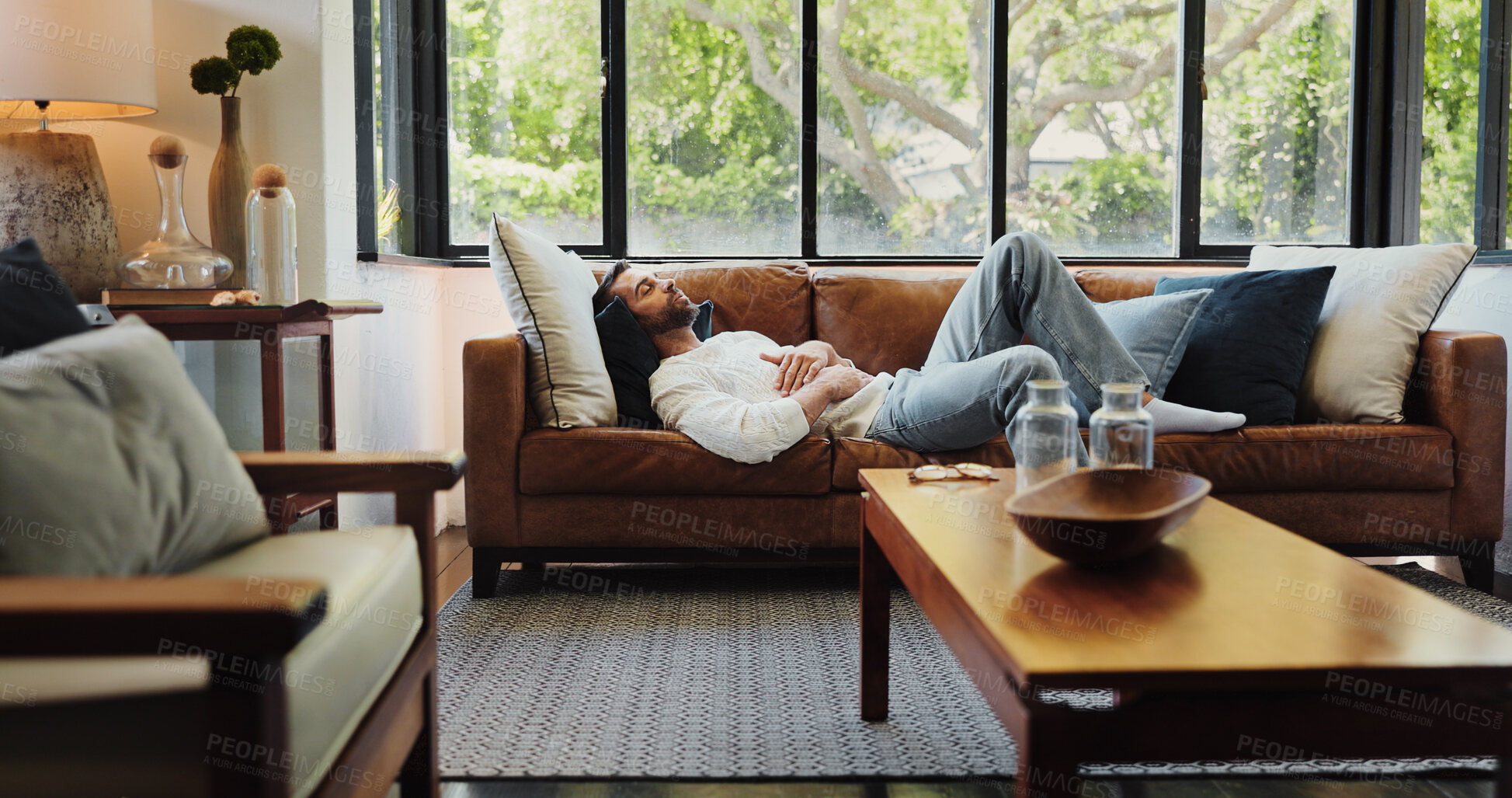Buy stock photo Home, relax and man on sofa, sleeping and resting with weekend break in living room. Apartment, happy person and guy on couch, comfortable and chilling with peace, calm and easy with afternoon nap