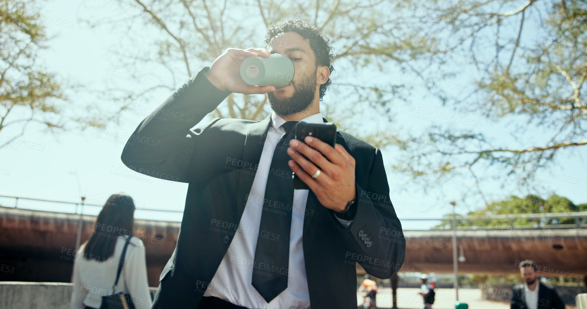 Buy stock photo Businessman, phone and coffee in city, park or drink with notification, chat or outdoor on commute. Person, low angle and click on mobile app for contact, networking or email on sidewalk in morning