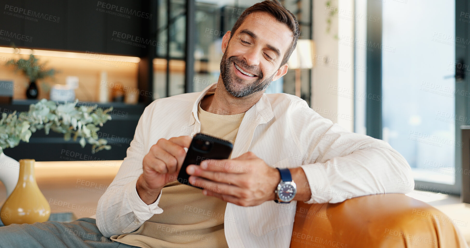 Buy stock photo Home, funny and man on sofa, smartphone and smile with message to contact, chatting and connection. Person, social media and guy with cellphone and internet with meme, humor or email notification