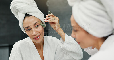 Buy stock photo Beauty, jade roller and mirror with woman in bathroom of home for antiaging dermatology treatment. Facial massage, reflection and skincare with person in apartment for morning cosmetic routine