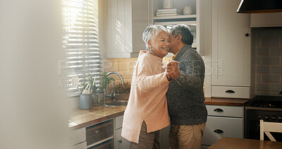 Buy stock photo Senior couple, dancing and kiss in kitchen with love, bonding and celebration for anniversary. People, man and woman with holding hands, retirement and happy for memory in relationship at apartment