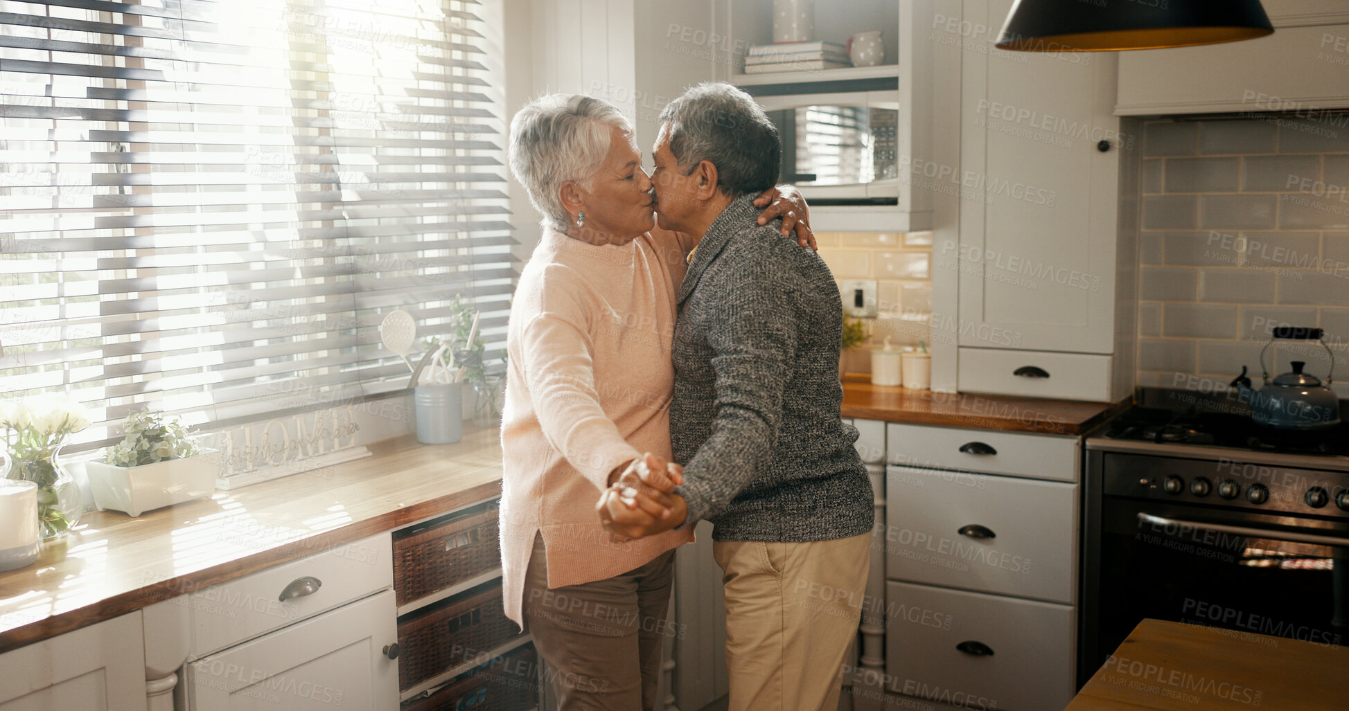 Buy stock photo Kiss, dance and senior couple with love in home for healthy relationship, connection or holding hands. Retirement, man and woman moving with romance music to celebrate marriage anniversary in kitchen