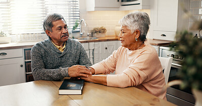 Buy stock photo Senior couple, bible and pray with faith in home, holding hands and religion with worship in retirement. Elderly man, woman and support for peace, book and together with praise, gratitude and God