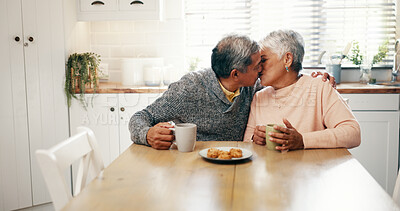 Buy stock photo Hug, kiss and senior couple with coffee, home and bonding with beverage in kitchen and elderly people. Happy, old man and mature woman with tea in house, comfortable and embrace for love in morning