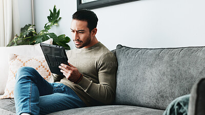 Buy stock photo Tablet, reading and man on sofa in home with online blog, post or news article for politics. Digital technology, research and male person with social networking on media in living room at apartment.
