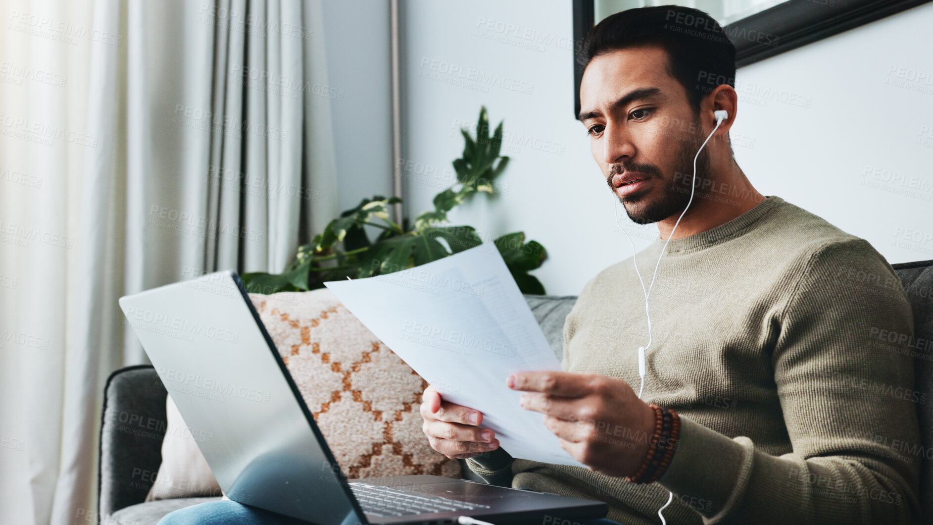 Buy stock photo Home, earphones and man on laptop with documents on sofa for online course, lesson and business seminar. Remote work, living room and person on computer listening to podcast, audio or read transcript