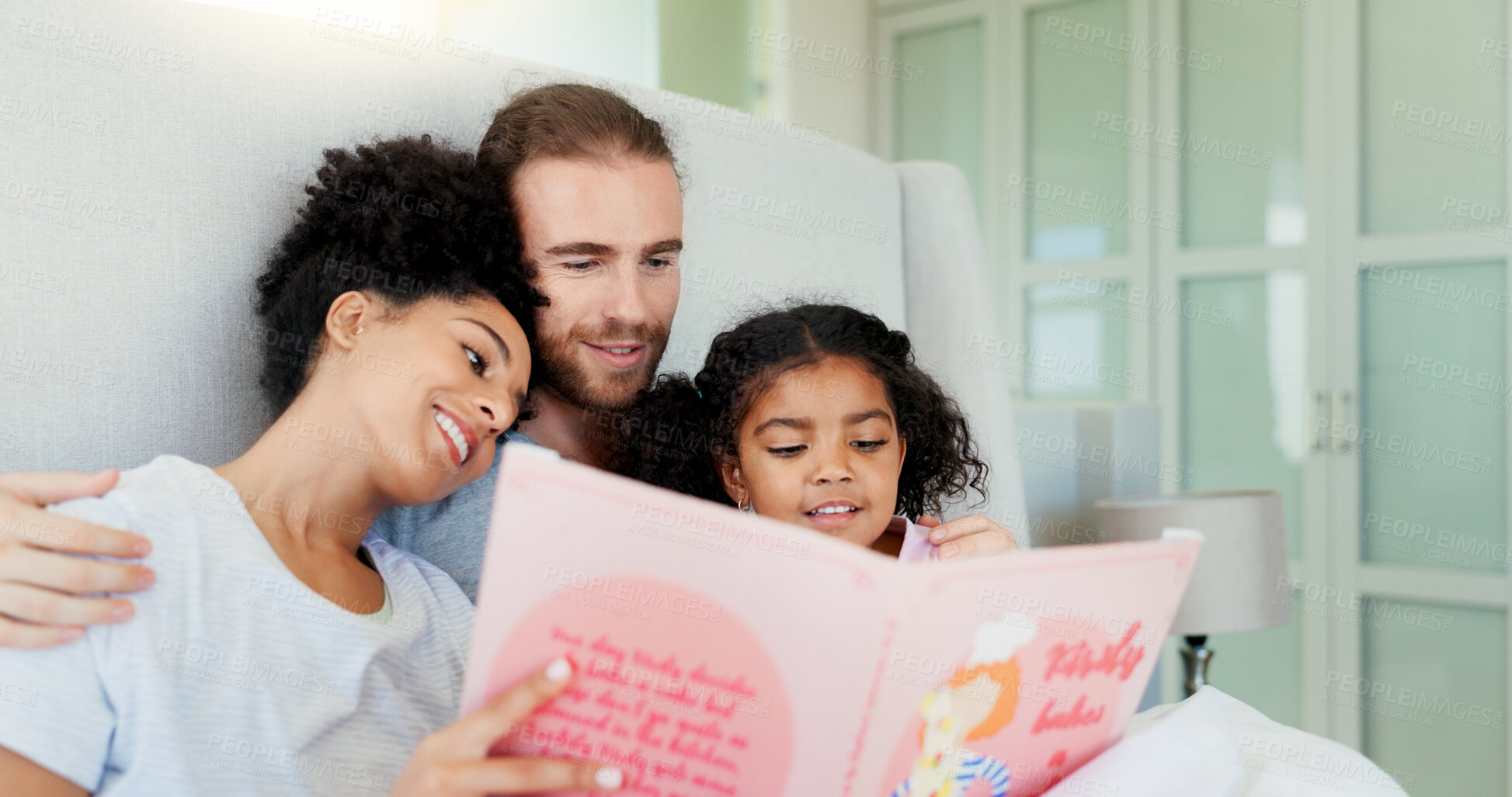 Buy stock photo Parents, girl and reading book in bed for story, happy and learning with care, embrace or language in home. Father, mother and daughter with hug, love or smile for bonding at interracial family house