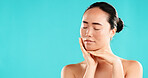 Eyes closed, dermatology and Asian woman with cosmetics, aesthetic and beauty on blue studio background. Person, mockup space and model with skincare, wellness and natural glow with healthy skin