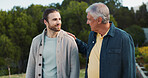Father, son and walk with comfort at park for family reunion, bonding together and summer vacation. Smile, senior dad and men with discussion, support and travel journey with parent advice in nature