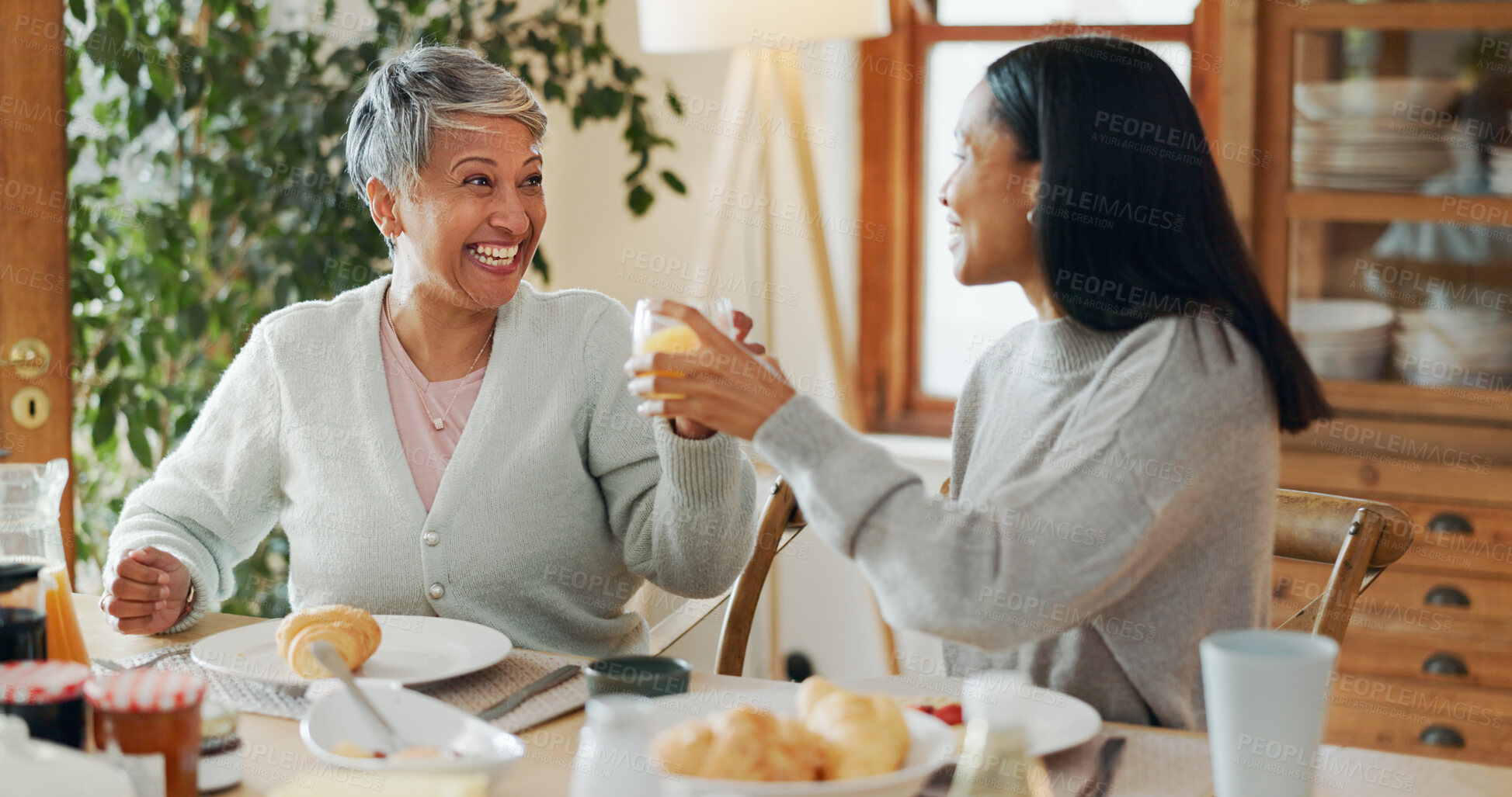 Buy stock photo Home, breakfast and senior mother with adult daughter, cheers and bonding together. Family, parent and women with juice, healthy food or nutrition with announcement, good news and happiness with love
