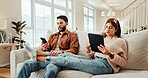 Distraction, streaming and technology with couple on sofa in living room of apartment for social media. App, phone or tablet with man and woman in apartment for connectivity or screen addiction