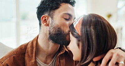 Buy stock photo Couple, relax and kiss forehead at house for affection, love and partner support in living room. People, romance and bonding together for relationship commitment, connection and sofa of weekend break