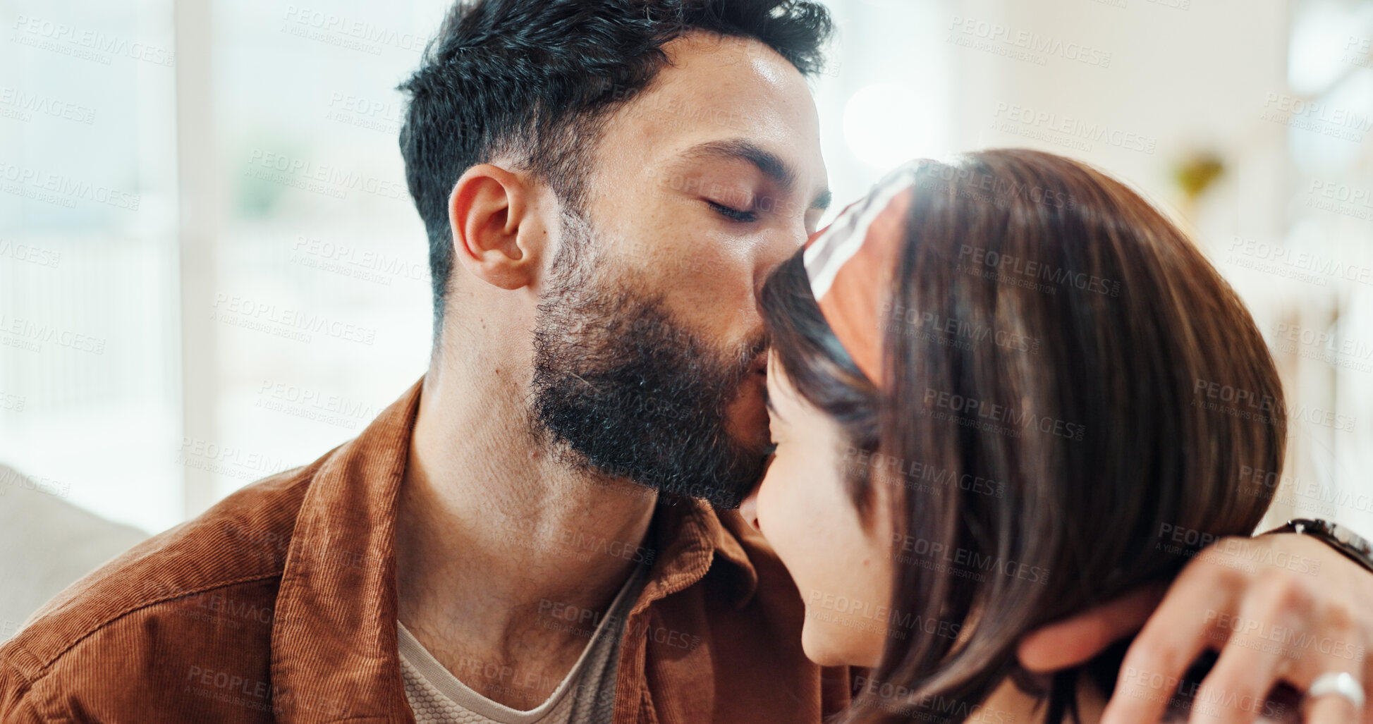 Buy stock photo Couple, relax and kiss forehead at house for affection, love and partner support in living room. People, romance and bonding together for relationship commitment, connection and sofa of weekend break