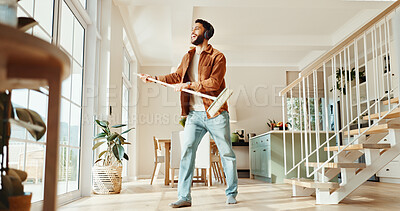 Buy stock photo Broom, energy and music with man in home for chores, responsibility or spring cleaning. Headphones, sing and sweeping with happy person in apartment for housekeeping, listening or radio streaming