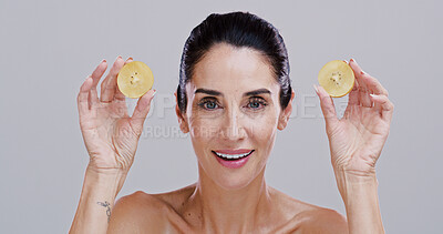 Buy stock photo Portrait, kiwi and woman with skincare, beauty and dermatology on gray studio background. Face, mature person and model with organic cosmetics, natural detox and shine with wellness and healthy skin