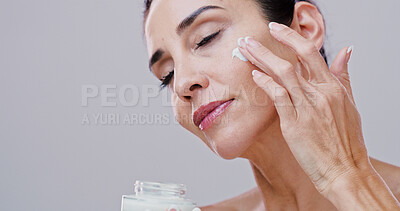 Buy stock photo Beauty, mature woman and face cream in studio for anti aging treatment, wrinkle reduction and skin hydration. Mockup, person or skincare product application for self care wellness on white background