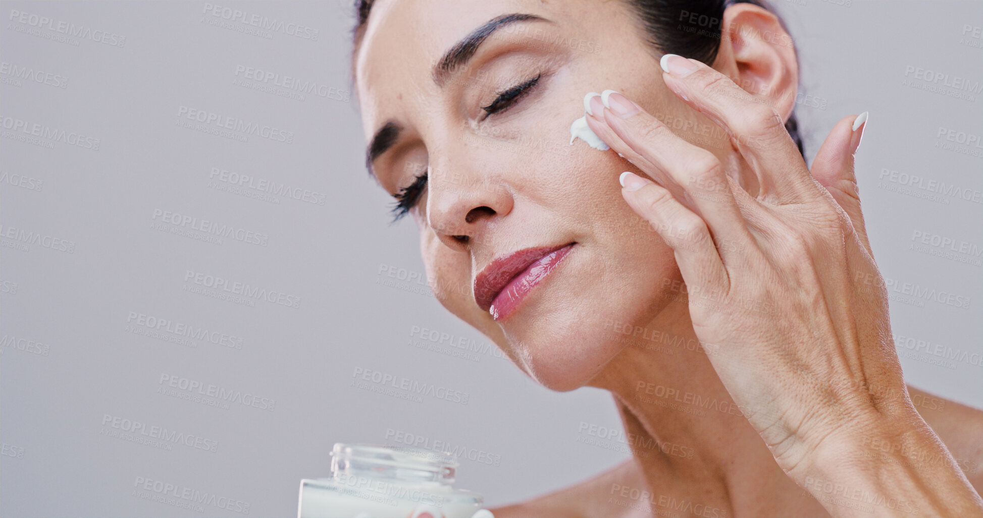Buy stock photo Beauty, mature woman and face cream in studio for anti aging treatment, wrinkle reduction and skin hydration. Mockup, person or skincare product application for self care wellness on white background
