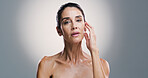 Portrait, studio and mature woman with skincare, confident and treatment for shine of skin and cosmetics. Gray background, mockup space and glow with dermatology, proud and wellness for person