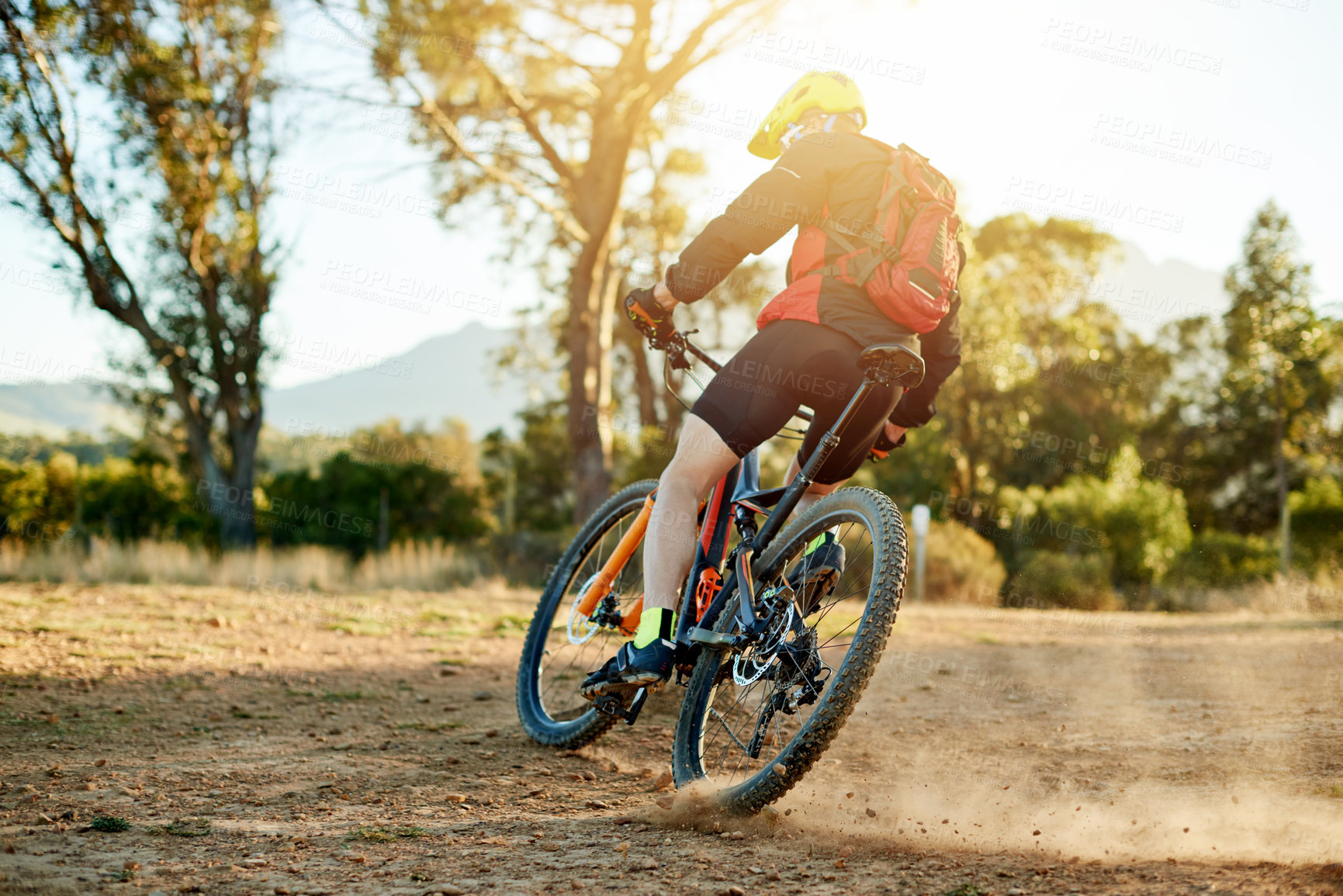 Buy stock photo Mountain bike, cycling and back of cyclist with sports race, workout or cardio exercise on dirt road. Fitness, triathlon and athlete riding on dust trail for competition training with adventure.