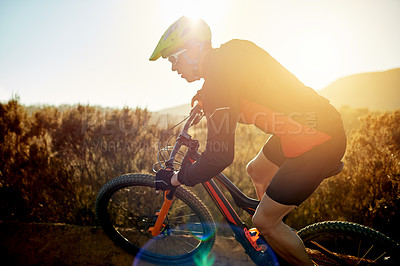 Buy stock photo Man, cyclist and mountain bike with sunset or adrenaline rush on dirt road for fitness or extreme sport in nature. Male person, bicycle and cycling with helmet for cardio workout on path or trail