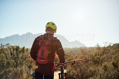 Buy stock photo Man, walking or bike in nature for fitness, journey or travel break on trail. Back, tired athlete or bicycle on mountain path for morning workout, explore track or trekking with sky space in Germany