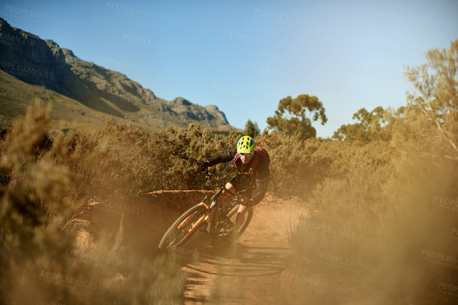 Buy stock photo Man, cyclist and mountain with bike for extreme cycling, off road or dirt track in nature. Active, male person or biker riding with helmet on desert terrain under blue sky in outdoor wilderness