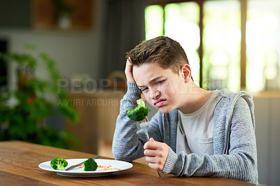 Buy stock photo Upset, child and dislike broccoli at table for eating vegetables and no to nutrition at home. Healthy lunch, salad and face with disgust, refuse meal and fussy eater with balanced diet and food