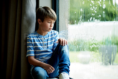 Buy stock photo Rain, boy child and sad by window for gloomy weather with disappointment, bored and unhappy. Depression, kid and stuck in home with winter day, thinking or watching view with contemplation and lonely