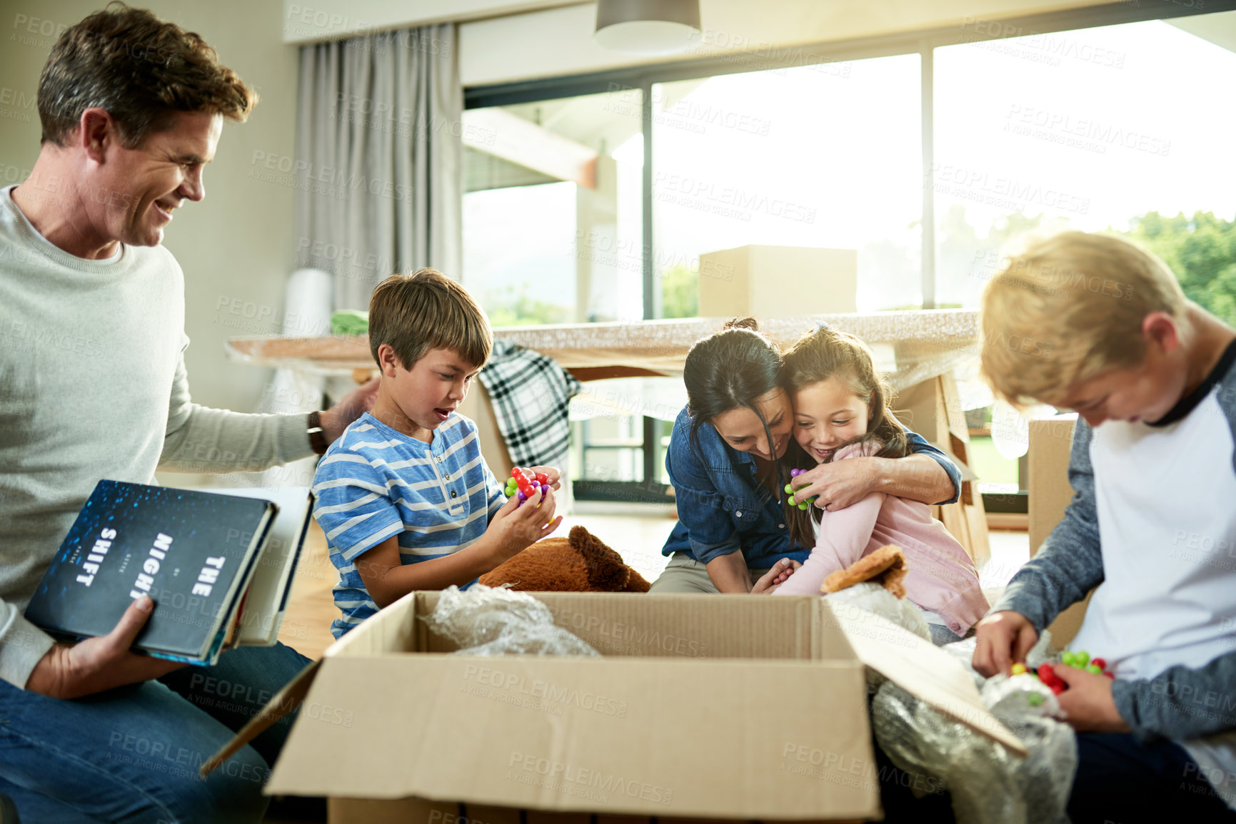 Buy stock photo Hug, boxes and family packing in new home with sorting items for donation, charity or community. Cardboard, moving and parents helping children sort household supplies for relocation in house.