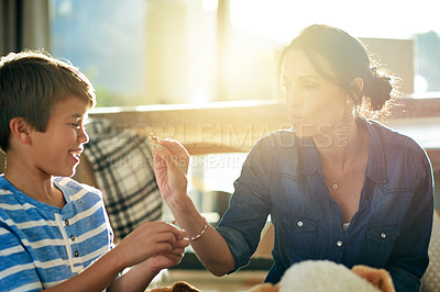 Buy stock photo Child development, mother and son playing with toy cat in home together for growth or learning. Lens flare, motor skills and smile with woman teaching happy boy in apartment for animal education